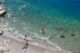 Παραλία με κόσμο που κολυμπά και κάνει ηλιοθεραπεία στην Ύδρα